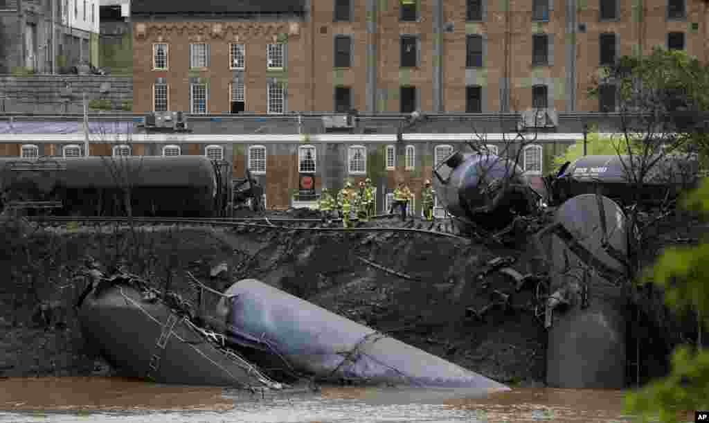 Firefighters and rescue workers work along the tracks where CSX tanker cars carrying crude oil derailed and caught fire in Lynchburg, Virginia, USA.