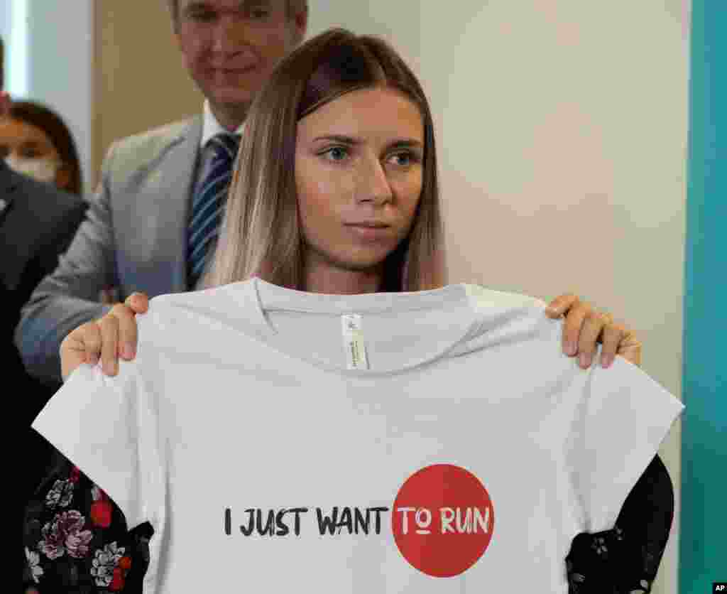 Belarusian Olympic sprinter Krystsina Tsimanouskaya shows an Olympic-related T-shirt with her slogan &quot;I Just Want to Run&quot; after her news conference in Warsaw, Poland.
