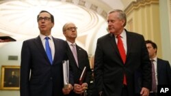 Treasury Secretary Steven Mnuchin, left, accompanied by White House Legislative Affairs Director Eric Ueland and acting White House chief of staff Mark Meadows, speaks with reporters as he walks to the offices of Senate Majority Leader Mitch McConnell