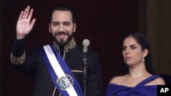 ARCHIVO - El presidente de El Salvador, Nayib Bukele, saluda desde un balcón acompañado por la primera dama Gabriela Roberta Rodríguez después de juramentar para un segundo mandato, en San Salvador, El Salvador, el sábado 1 de junio de 2024.