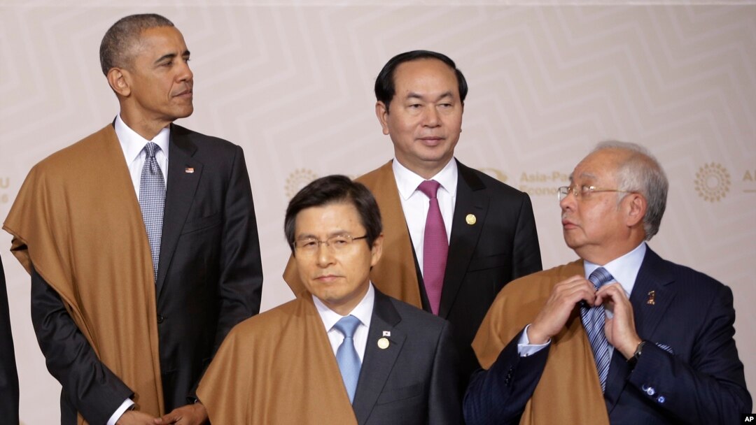 PM Malaysia Najib Razak membetulkan dasinya sambil menunggu Presiden AS Barack Obama, kiri atas, PM Korsel Hwang Kyo-ahn, kiri depan, dan Presiden Vietnam Tran Dai Quang untuk foto bersama pada pertemuan puncak tahunan APEC (20/11). Lima, Peru. (foto: AP Photo/Martin Mejia)