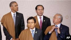 PM Malaysia Najib Razak membetulkan dasinya sambil menunggu Presiden AS Barack Obama, kiri atas, PM Korsel Hwang Kyo-ahn, kiri depan, dan Presiden Vietnam Tran Dai Quang untuk foto bersama pada pertemuan puncak tahunan APEC (20/11). Lima, Peru. (foto: AP Photo/Martin Mejia)