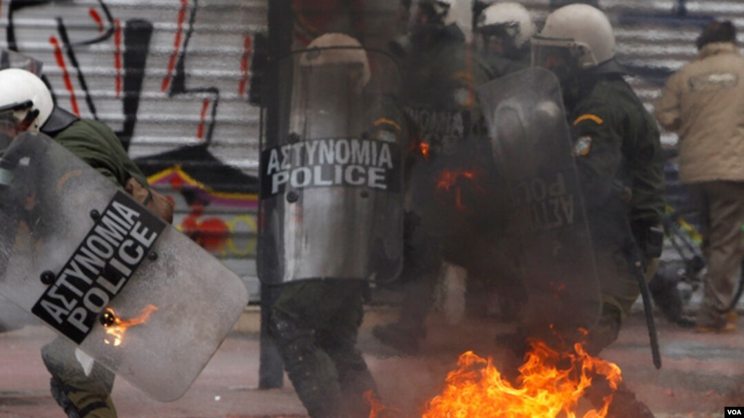 Para demonstran Yunani yang marah atas langkah-langkah penghematan pemerintah melempar bom molotov ke arah polisi di Athena (10/2).