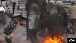 Para demonstran Yunani yang marah atas langkah-langkah penghematan pemerintah melempar bom molotov ke arah polisi di Athena (10/2).