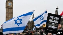 Manifestantes con banderas israelíes y pancartas marchan contra el antisemitismo frente al conocido reloj Big Ben en el centro de Londres el 26 de noviembre de 2023.