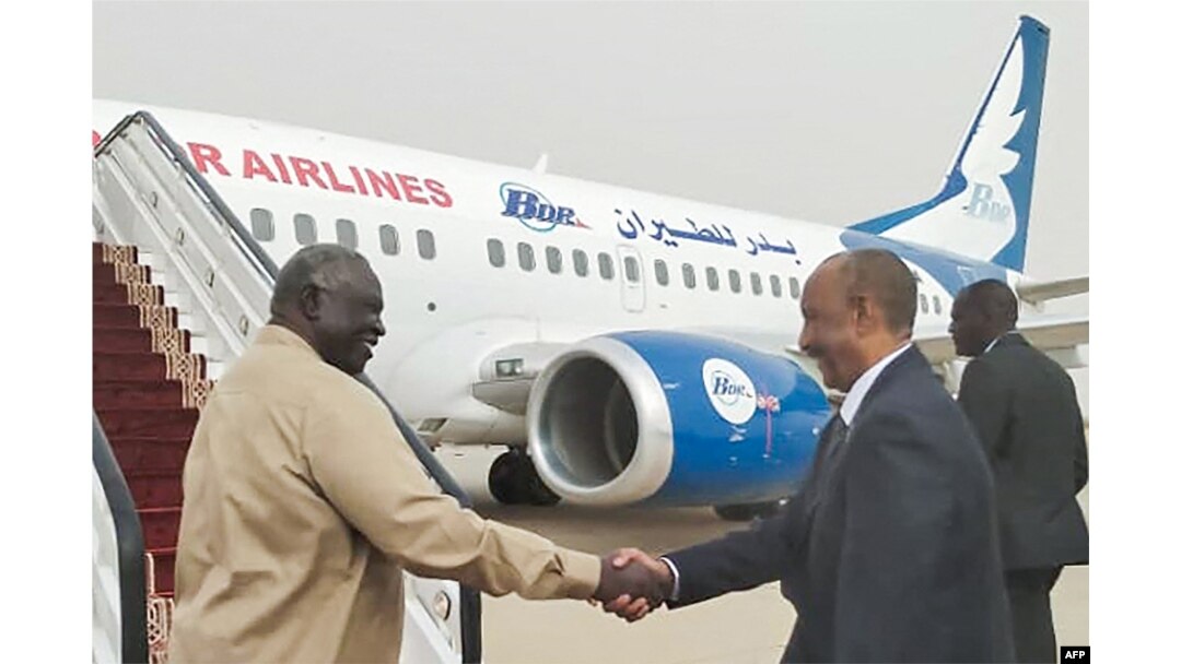 FILE - A handout picture provided by Sudan's Transitional Sovereignty Council on August 29, 2023, shows Sudanese Army chief and the council's chairman General Abdel Fattah al-Burhan (R) boarding an airplane heading for Egypt at Port Sudan's airport.