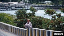 FILE - A man sits on a wall near the Indus River in Gilgit.