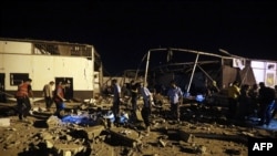 Emergency workers and other recover bodies after an airstrike killed nearly 40 at Tajoura Detention Center, east of Tripoli on early July 3, 2019. 