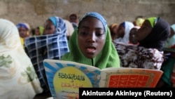  Une jeune fille lit des versets dans une école coranique le 2e jour du mois sacré du Ramadan dans la ville de Kano, au nord du Nigeria, le 21 juillet 2012.