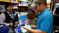 Hugo Roque, de Glendale, California, hace una compra en una tienda Disney.