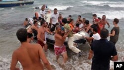 意大利海岸警卫帮助偷渡者下船上岸 