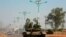 FILE - A military tank patrols along one of the main roads in the South Sudanese capital Juba, Dec. 16, 2013. Three deadly road attacks occurred in South Sudan this week, leaving 10 people dead. 