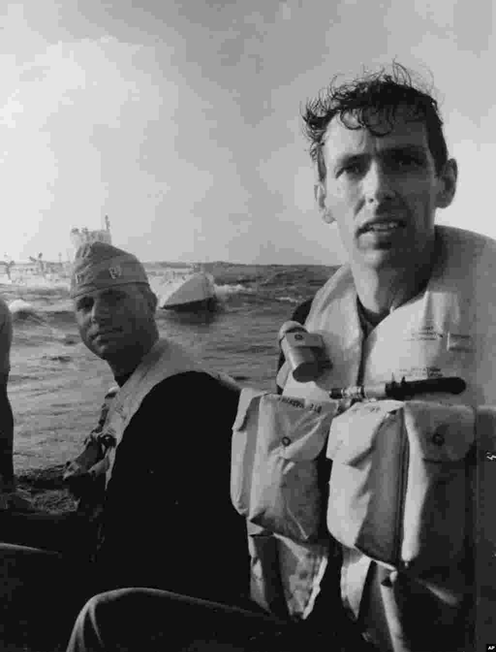 After their successful nine-hour dive in January 1960 to the bottom of the Mariana Trench, Don Walsh and Jacques Piccard emerge from the bathyscaphe Trieste. James Cameron will attempt to make only the second successful manned descent to this deepest part