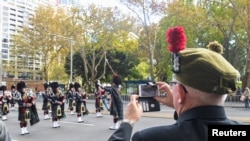 A veteran records a band with his phone as Australian military personnel, past and present, commemorate ANZAC Day during a march through the city center in Sydney, Australia, April 25, 2021. Many Australians and New Zealanders consider it one of the most sacred days of the year.