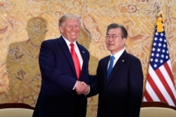 President Donald Trump and South Korean President Moon Jae-in shakes hands at the start of a bilateral meeting at the Blue House in Seoul, Sunday, June 30, 2019.