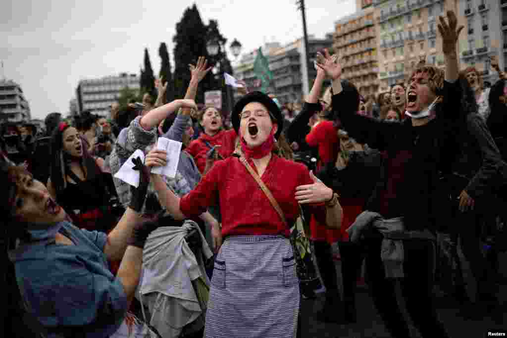 People dance and sing during a demonstration to mark International Women's Day in front of the parliament building in Athens, Greece.