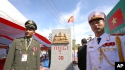 FILE PHOTO - A Cambodian army officer, left, and a Vietnamese army officer stand in front of a newly launched border mark (on the Cambodian side) in between Gia Lai province of Vietnam and Rattanakiri of Cambodia on Saturday, Dec. 26, 2015. 