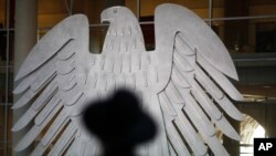 La sombra de un rabino se refleja frente a la heráldica águila alemana durante una reunión especial del Bundestag en Berlín, el miércoles 27 de enero de 2021, para conmemorar a las víctimas del Holocausto.