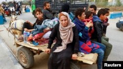 FILE - Palestinians flee north Gaza to move southward as Israeli tanks roll deeper into the enclave, amid the ongoing conflict between Israel and Hamas, in the central Gaza Strip November 12, 2023.