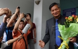 FILE - Nguyen Quang A, a prominent dissident, speaks to supporters as he leaves a consultative meeting with local residents in Hanoi, April 9, 2016.