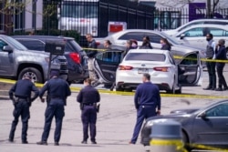 FILE - Law enforcement confer at the scene, April 16, 2021, in Indianapolis, where multiple people were shot at a FedEx Ground facility near the Indianapolis airport.