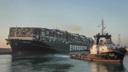 Dalam foto yang dirilis Otoritas Terusan Suez ini terlihat Ever Given, sebuah kapal kargo berbendera Panama, ditarik oleh salah satu kapal tunda Terusan Suez, di Terusan Suez, Mesir, Senin, 29 Maret 2021. (Foto: AP)