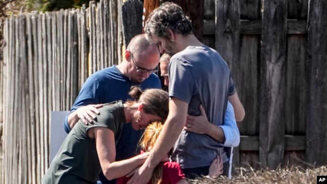 Un grupo ora con un niño afuera del centro de reunificación en la iglesia bautista de Woodmont después de un tiroteo en una escuela, el lunes 27 de marzo de 2023, en Nashville, Tennessee.