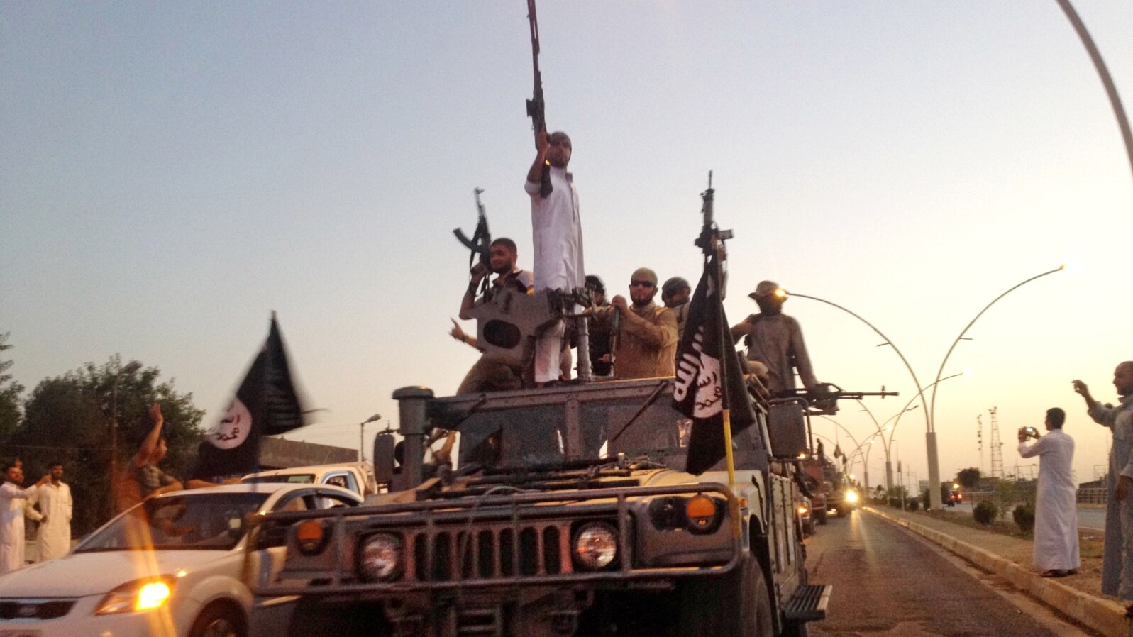 FILE - Islamic State militants flaunt an armored vehicle seized from Iraqi security forces in the northern Iraq city of Mosul on June 23, 2014.