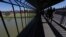 FILE - People walk back to Mexico on International Bridge 1 Las Americas, a legal port of entry which connects Laredo, Texas, in the U.S. with Nuevo Laredo, Mexico, July 18, 2019.