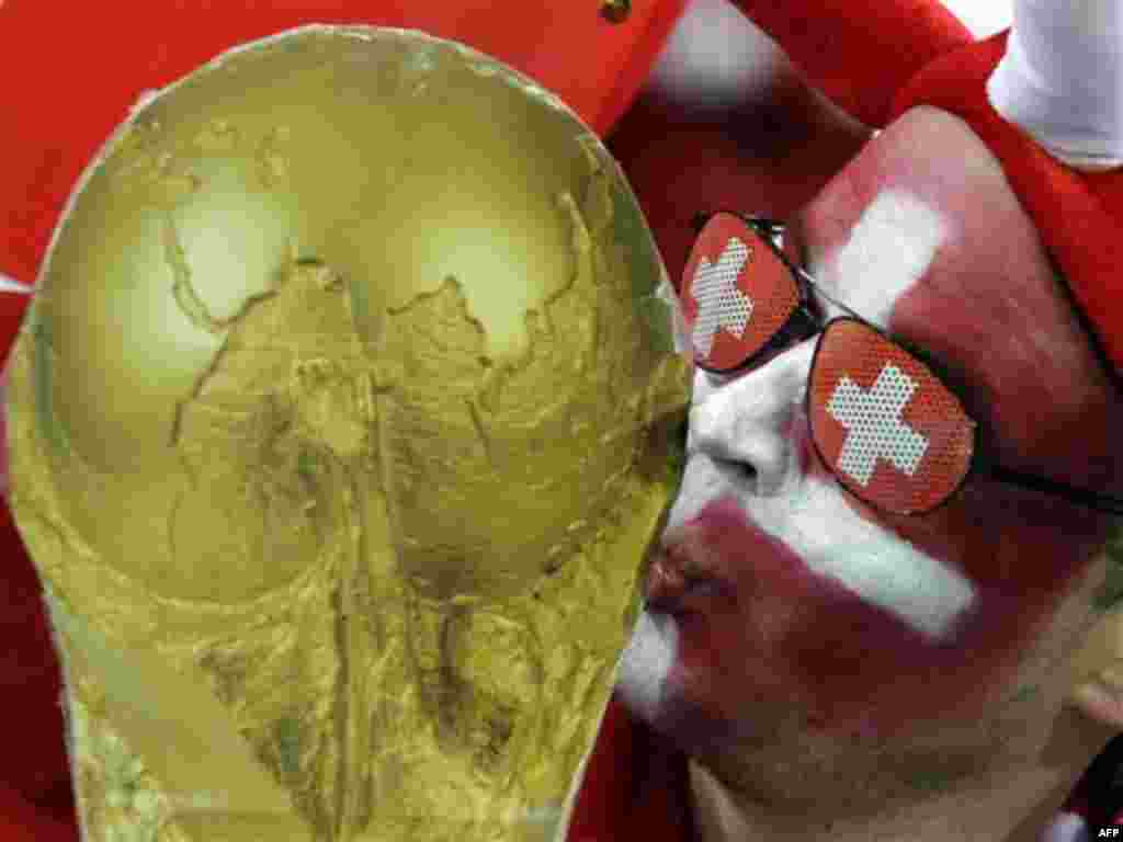 A Swiss fan kisses replica World Cup trophy during the World Cup group H soccer match between Spain and Switzerland at the stadium in Durban, South Africa, Wednesday, June 16, 2010. Switzerland won 1-0. (AP Photo/Schalk van Zuydam)