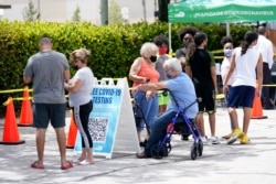 People wait in line at a Miami-Dade County COVID-19 testing site in Hialeah, Florida, July 26, 2021. Florida accounted for a fifth of the nation's new infections last week, more than any other state, according to the U.S. Centers for Disease Control.