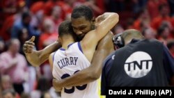 Košarkaši Golden Stejta Kevin Durent i Stef Kari grle se posle pobede nad Hjustonom u sedmoj utakmici finala Zapadne konferencije NBA plej-ofa, 28. maja 2018. (Foto: AP/David J. Phillip))