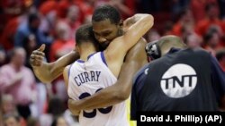 Kevin Durant des Golden State Warriors et son coéquipier Stephen Curry, après leur victoire sur les Houston Rockets, Houston, Texas, le 28 mai 2018.