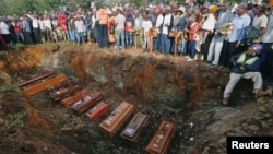 Coffins are seen arranged inside a mass grave during the burial of people killed when a dam burst its walls, overrunning nearby homes, in Solai town near Nakuru, Kenya, May 16, 2018. 