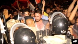 Iraqi riot police prevent protesters from storming the provincial council building during a demonstration in Basra, 340 miles (550 kilometers) southeast of Baghdad, Iraq, early Saturday, May 21, 2016. 