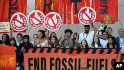 Activistas participan en una demostración para poner fin a los combustibles fósiles este 12 de diciembre durante el cierre de la Conferencia Global sobre Cambio Climático organizada por la ONU y realiuzada en Dubai.