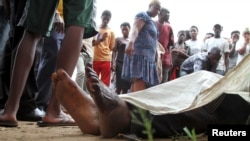 FILE - Residents look at the slain bodies of people killed at the Cibitoke district in Burundi's capital Bujumbura, Dec. 9, 2015. 