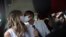 Wearing masks to prevent the spread of the new coronavirus, Thiago do Nascimento, right, and Keilla de Almeida kiss during their drive-thru wedding at the registry office in the neighborhood of Santa Cruz, Rio de Janeiro, Brazil, May 28, 2020.