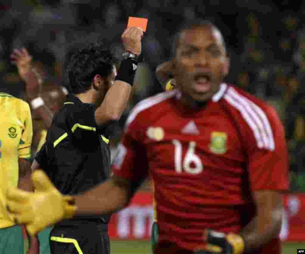 Swiss referee Massimo Busacca, left, holds up a red card for South Africa goalkeeper Itumeleng Khune, foreground, during the World Cup group A soccer match between South Africa and Uruguay at the Loftus Versfeld Stadium in Pretoria, South Africa, Wednesda