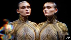 Un modèle, vu à travers un verre déformant, porte une création pour l'automne-hiver d'Iris Van Herpen, lors de la fashion week à Paris, le mardi 8 mars 2016. (AP Photo/Thibault Camus) 