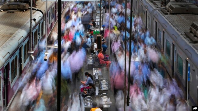 FILE- Women rest on a bench at the churchgate railway station during peak hours in Mumbai, India, Thursday, March 20, 2023. India’s Parliament has approved landmark legislation that reserves 33% of the seats in its powerful lower house and in state legislatures for women.