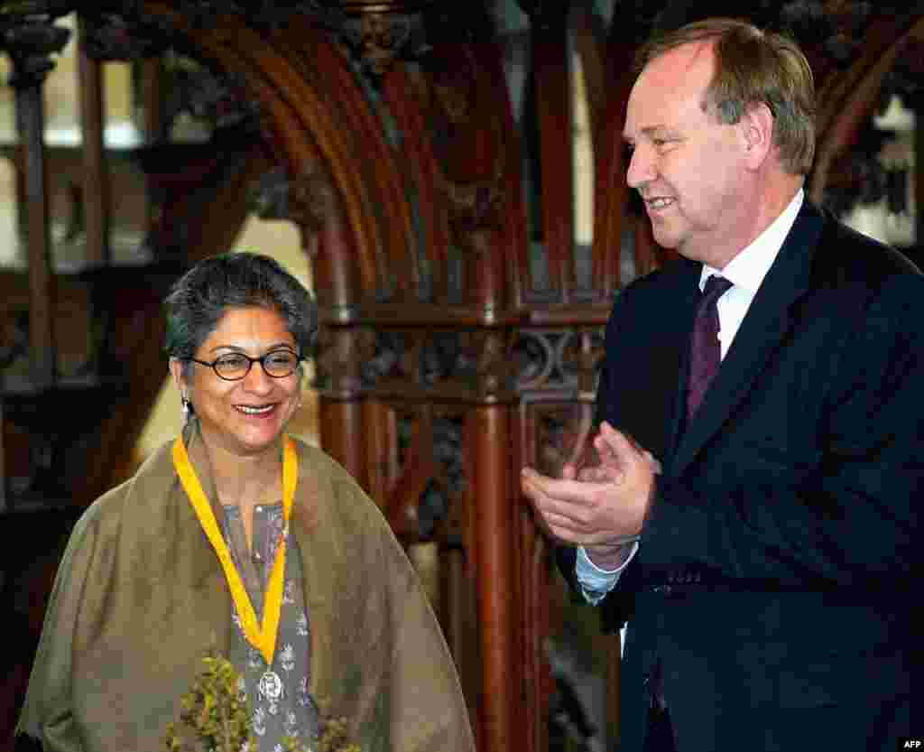 مارچ 2002ء: نیدرلینڈز میں ہونے والی ایک تقریب میں عاصمہ جہانگیر کا استقبال کیا جارہا ہے۔ اس تقریب کے دوران عاصمہ جہانگیر کو پاکستان اور دنیا بھر میں خواتین کے حقوق کے لیے کی جانے والی ان کی خدمات پر ایوارڈ دیا گیا تھا۔ تصویر میں دائیں جانب کھڑے صاحب نیدرلینڈ کے اس وقت کے وزیرِ قانون بینک کورتھالس ہیں۔