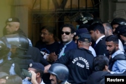 FILE - Security officers escort Pakistan's former Prime Minister Imran Khan, as he appeared in Islamabad High Court, Islamabad, Pakistan, May 12, 2023.