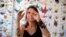 Karla Funderburk, seniman dan pemilik Matter Studio Gallery, di Los Angeles, AS, menata salah satu dari ribuan origami yang digantungnya dalam pameran yang digelar untuk menghormati para korban Covid-19, Selasa, 11 Agustus 2020. (Foto: dok).