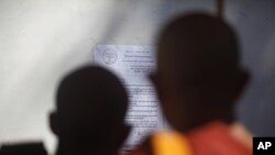 Buddhist monks look at a notice from the state committee of Sangha Maha Nayaka at the Shwenyawar monastery in Rangoon, December 15, 2011. The state committee of Sangha Maha Nayaka announced the removal of Pyi Nyar Thiha from the monastery after he preache
