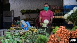 La pandemia de coronavirus ha aumentado la crisis económica en Cuba, por lo que el gobierno solicitó al Club de París prorrogar el pago de su deuda hasta 2022. En la foto un hombre usa una mascarilla en un mercado agrícola de La Habana.