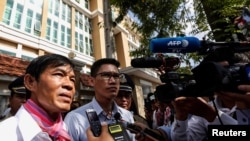 Uon Chhin and Yeang Sothearin, former journalists from the U.S.-funded Radio Free Asia (RFA), who have been charged with espionage, speak to the media in front of the Municipal Court of Phnom Penh, Cambodia, Oct. 3, 2019. 