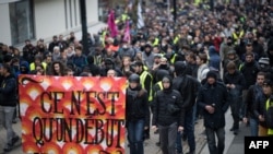 Protesters hold a banner reading "It's only the beginning" as they attend during a demonstration marking the first anniversary of the "yellow vest" movement on Nov. 16, 2019, in Nantes, western France.