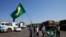 Truck drivers supporting Brazilian President Jair Bolsonaro wave flags as they gather at a gas station just south of Brasilia, Brazil, Sept. 9, 2021. 