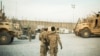 FILE - A U.S. soldier from the 3rd Cavalry Regiment walks with the unit's Afghan interpreter before a mission near forward operating base Gamberi in the Laghman province of Afghanistan, Dec. 11, 2014. 